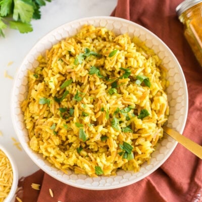 A bowl of orzo rice topped with chopped parsley