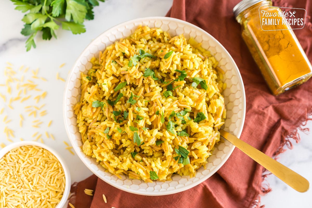 A bowl of orzo rice topped with chopped parsley