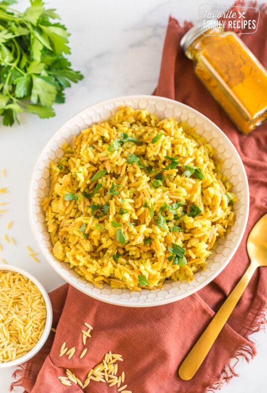 A bowl of orzo rice topped with chopped parsley