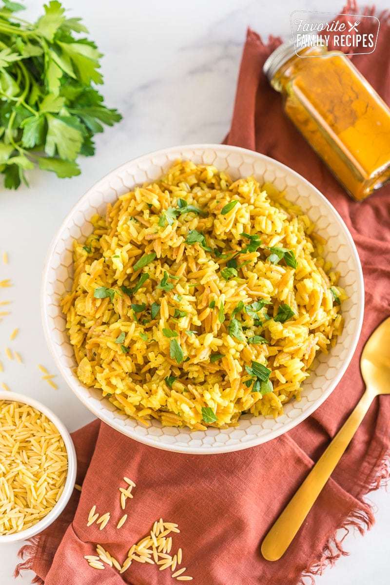 A bowl of orzo rice topped with chopped parsley