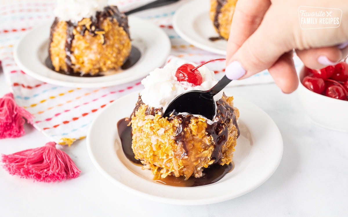 Spoon cutting into a ball of Fried Ice Cream.