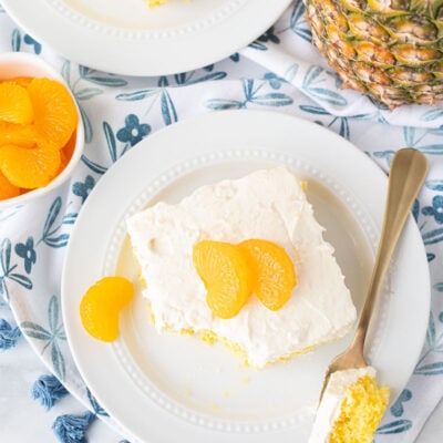 Two slices of Orange Cake with Pineapple Topping with a fork.