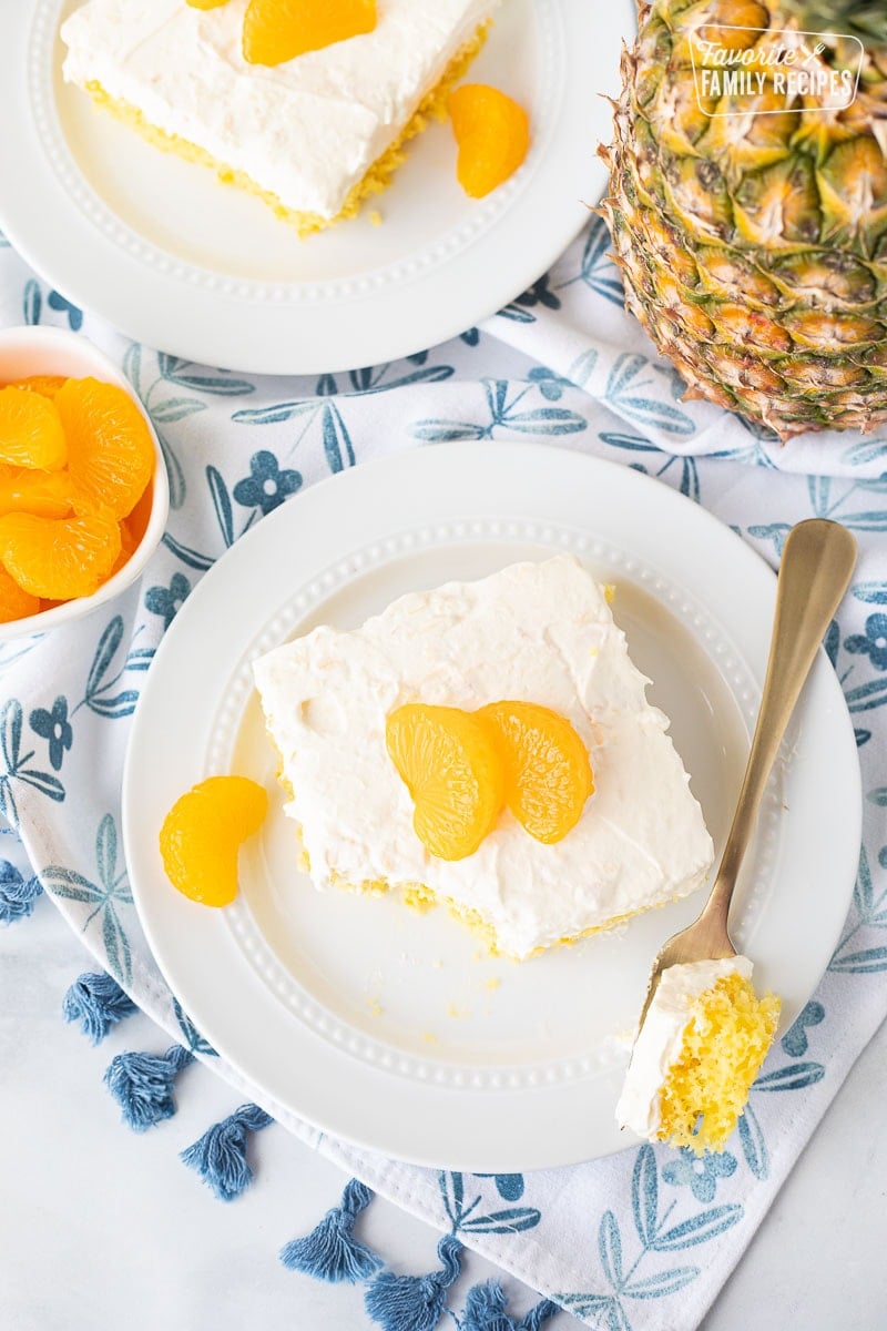 Two slices of Orange Cake with Pineapple Topping with a fork.