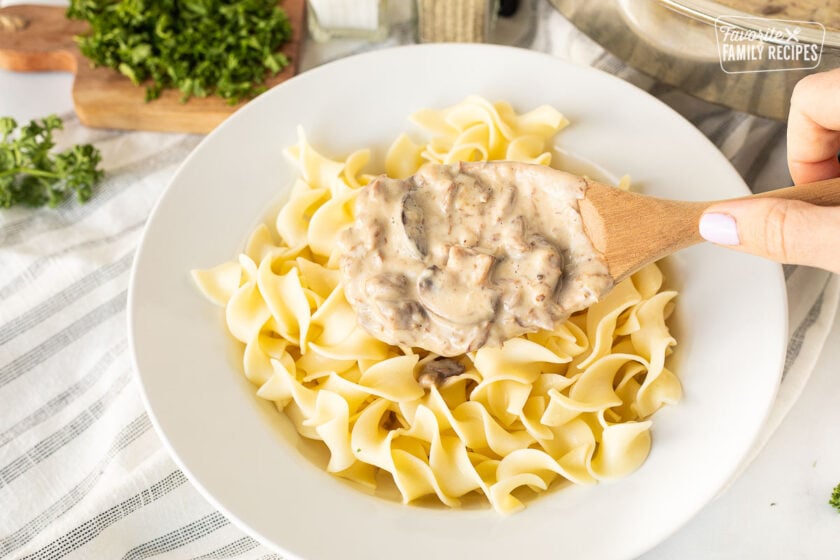 Pouring Easy Beef Stroganoff on noodles.