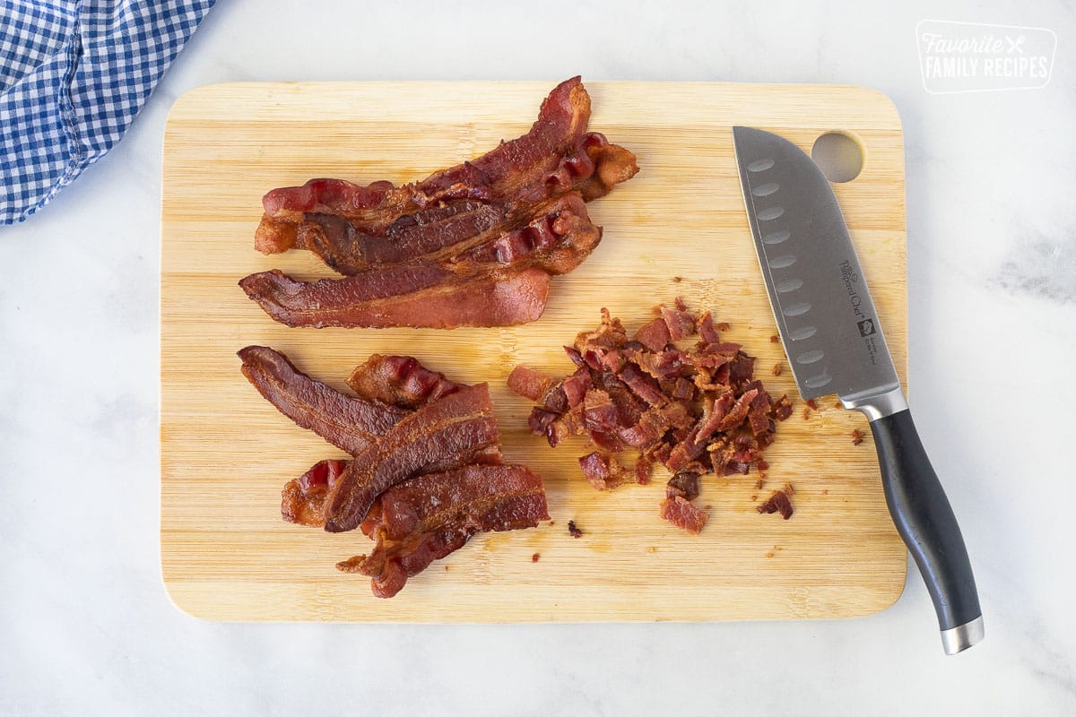Cutting up bacon on a cutting board for Baked Beans.