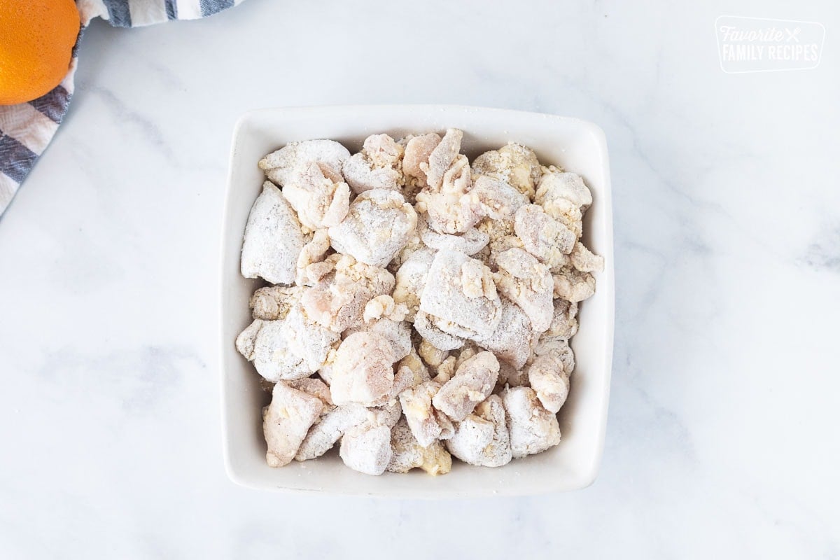 Battered chicken pieces for Orange Chicken in a dish.