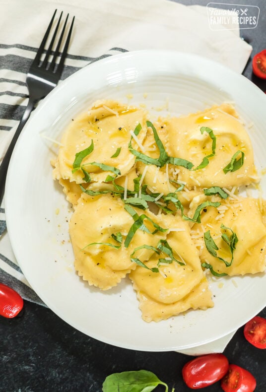 A bowl of homemade ravioli with olive oil and basil over the top