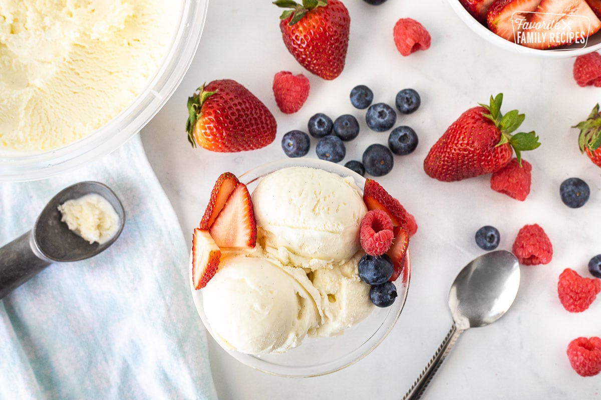 Bowl of Homemade Vanilla Ice Cream with blueberries, raspberries and sliced strawberries.
