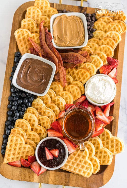 A breakfast charcuterie board with waffles and waffle toppings