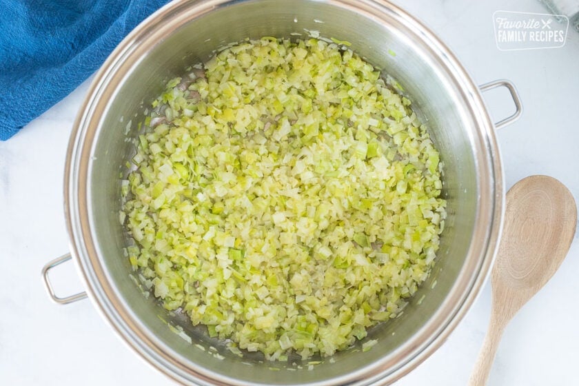 Pot with sautéed celery and onions for Seafood Chowder. Wooden spoon on the side.