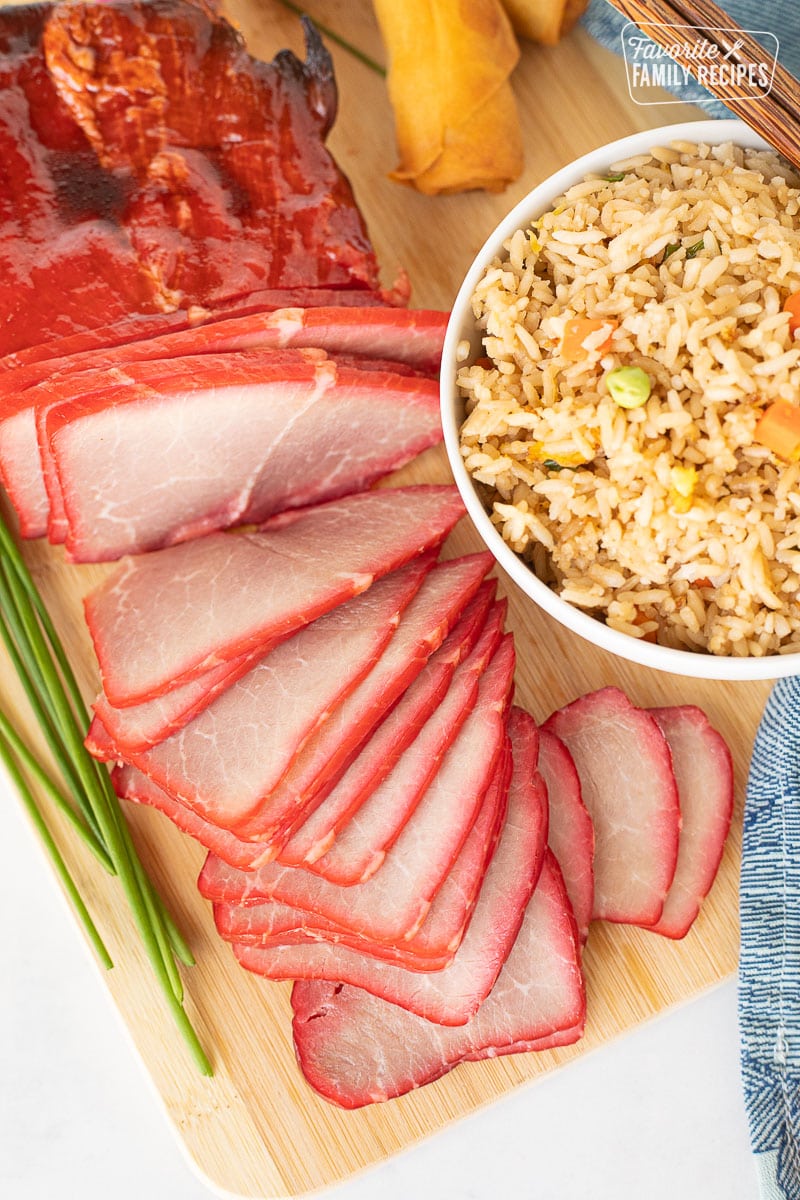 Sliced Char Siu (Chinese BBQ Pork) with fried rice and spring rolls.