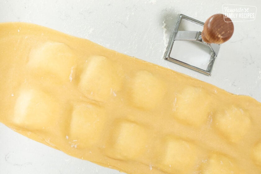 Dollops of ravioli filling between two sheets of pasta