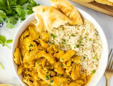 Bowl of Chicken Korma and rice with Naan bread.