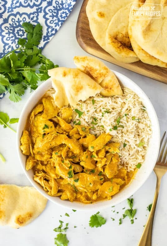 Bowl of Chicken Korma and rice with Naan bread.