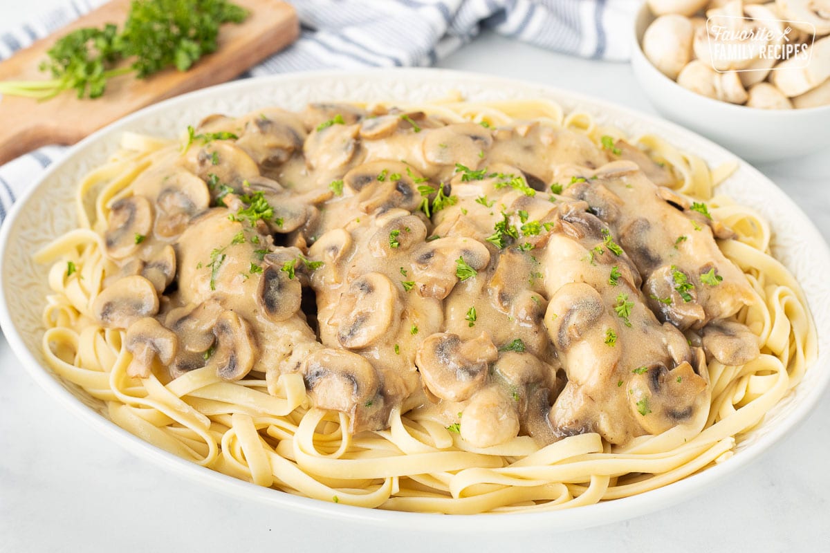 Large platter of Chicken Marsala over fettuccine pasta.