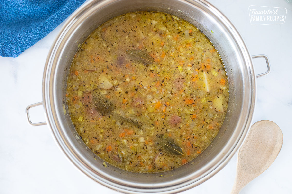 Pot with base with cooked vegetables for Seafood Chowder.