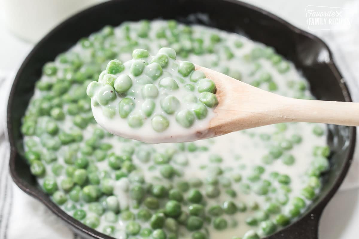 A close up of a spoonful of creamed peas