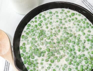 A cast-iron skillet with creamed peas