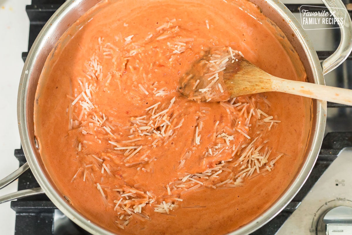 Parmigiano Reggiano being stirred into a ravioli sauce