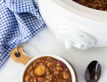 Bowl of Baked Beans next to the Crockpot of Baked Beans.