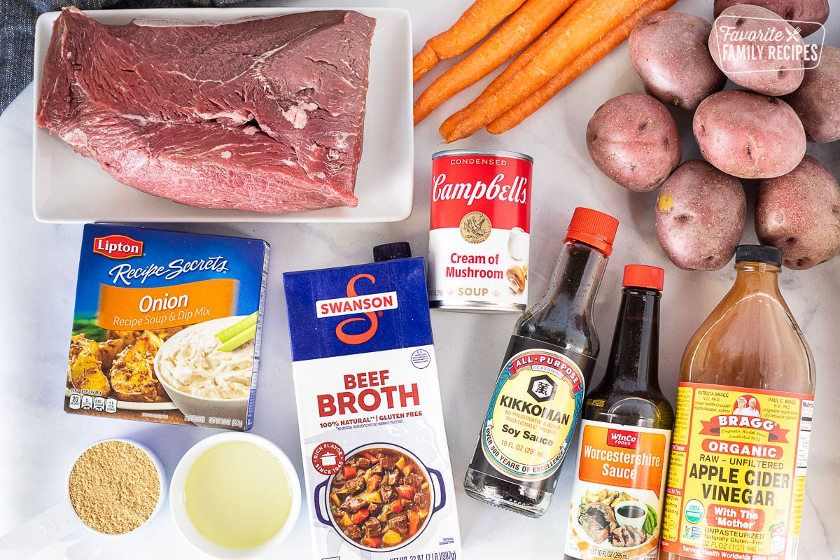 Ingredients to make Crockpot Roast Beef including Beef roast, carrots, red potatoes, cream of mushroom soup, soy sauce, Worcestershire sauce, apple cider vinegar, beef broth, onion soup mix, oil and brown sugar.