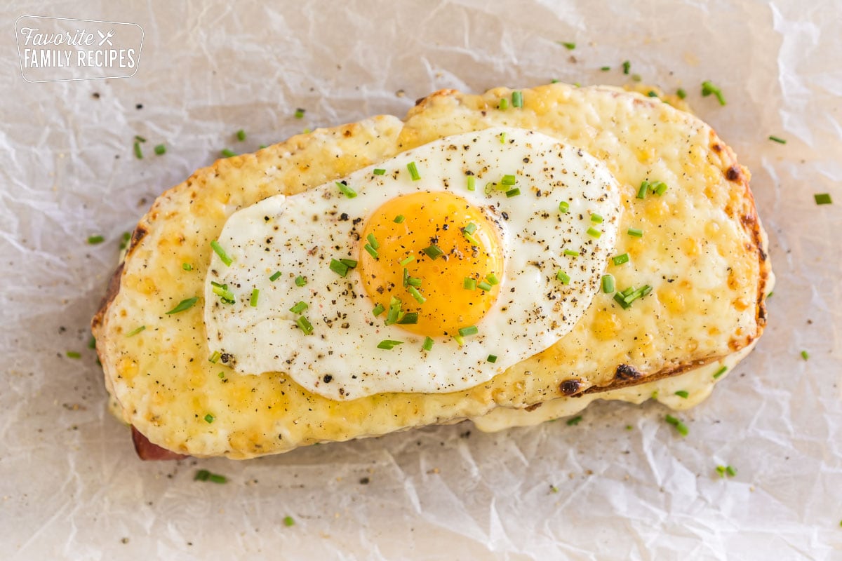 A croque madame topped with pepper and chives