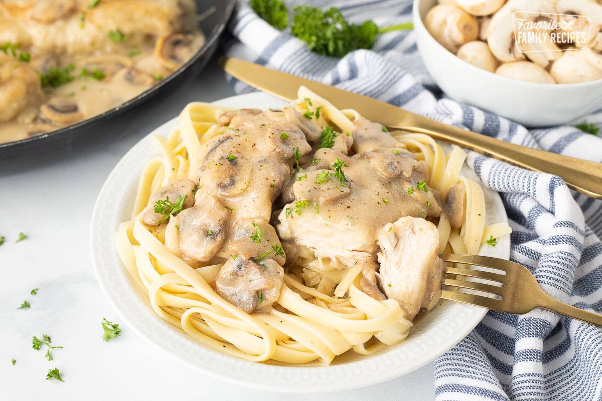 Cut up chicken Chicken Marsala with a fork and knife.