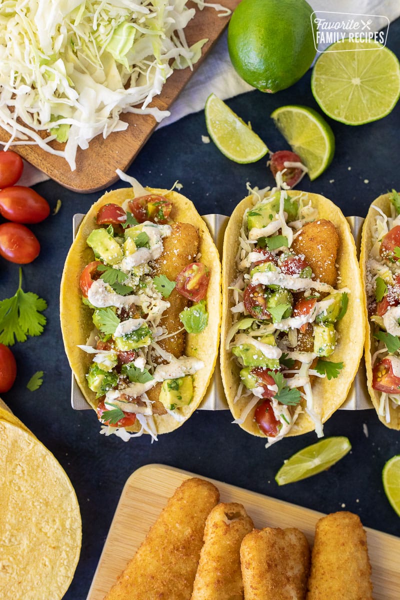 Easy Fish Tacos on a taco stand with lime wedges.