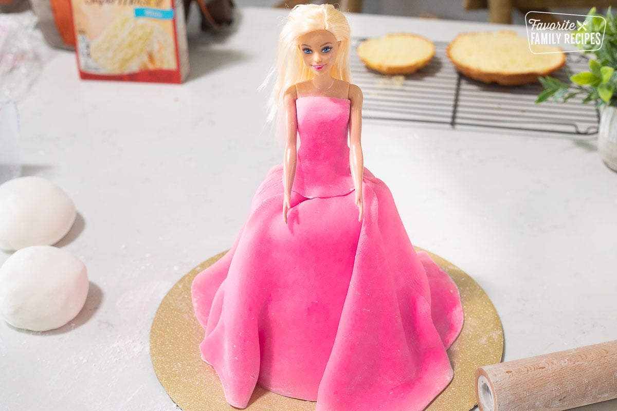 Wrapping Fondant around Barbie for Barbie Cake.