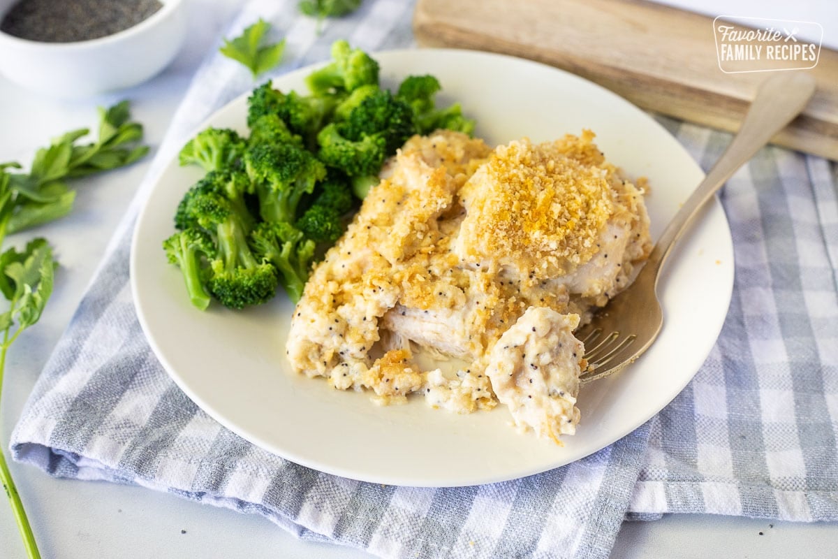 Plate with Poppy Seed Chicken, broccoli and a fork with a piece of Poppy Seed Chicken.