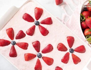 Fresh Strawberry Cake decorated with sliced strawberries and blueberries.