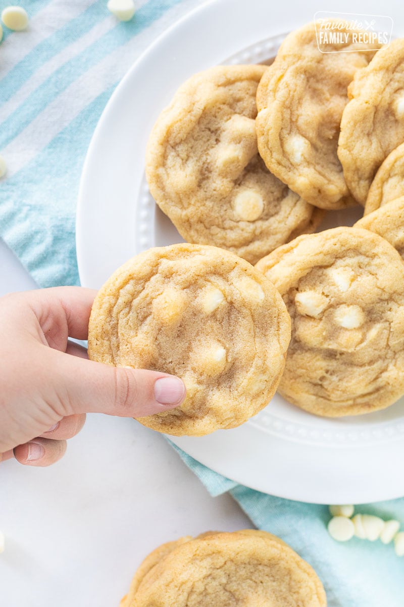 Hand holding a Vanilla Cookie over a plate of cookies.