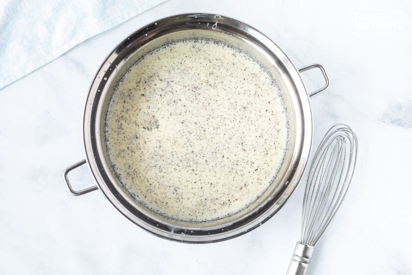 Pan of cooking Homemade Vanilla Ice Cream. Whisk on the side.