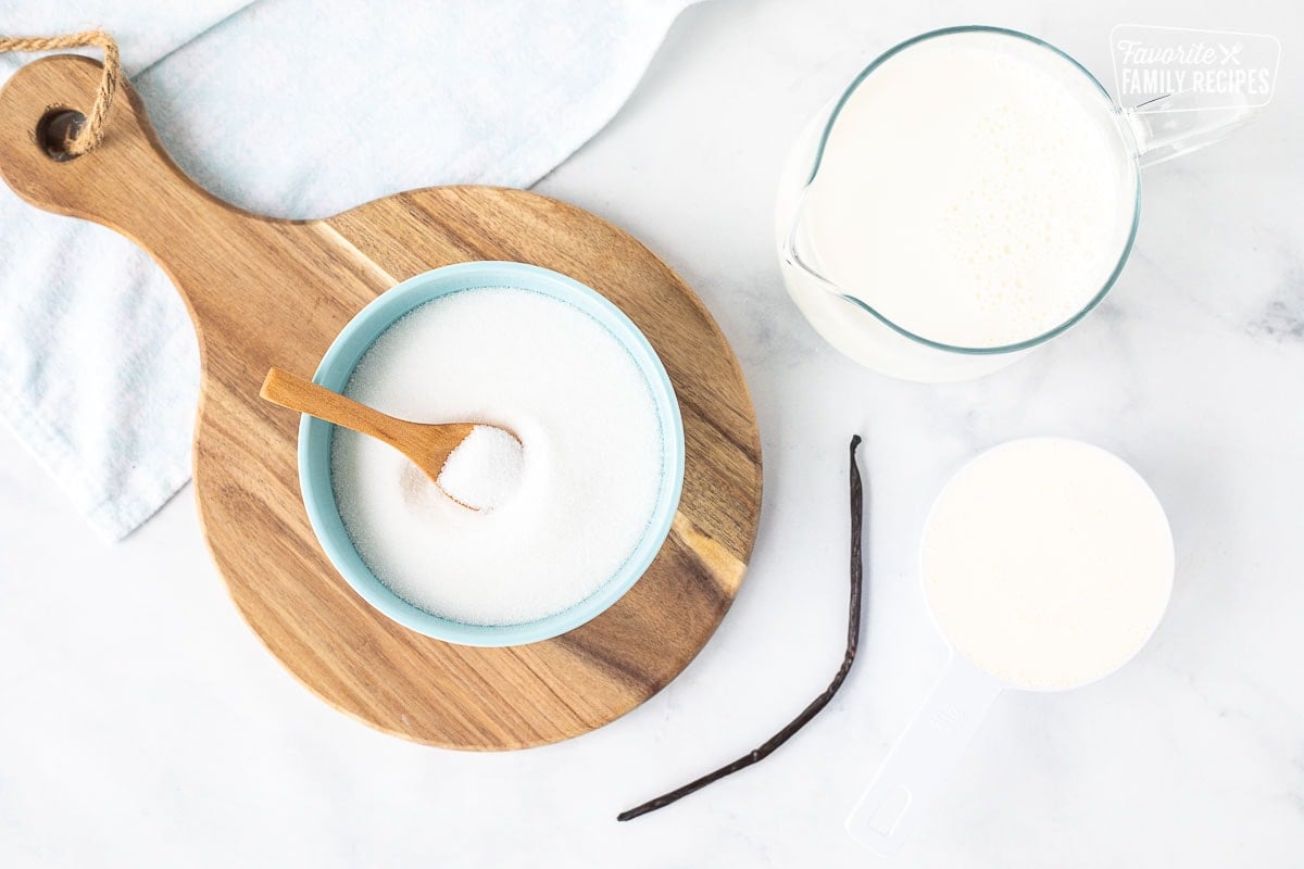 Ingredients to make Homemade Vanilla Ice Cream including, heavy cream, half and half, sugar and a vanilla bean.