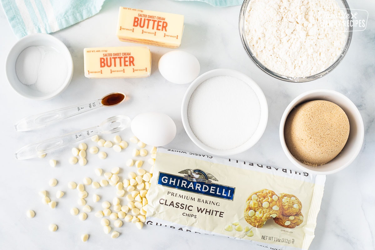 Ingredients to make Vanilla Cookies including butter, salt, baking soda, eggs, vanilla, almond extract, flour, sugar, brown sugar and Vanilla baking chips.