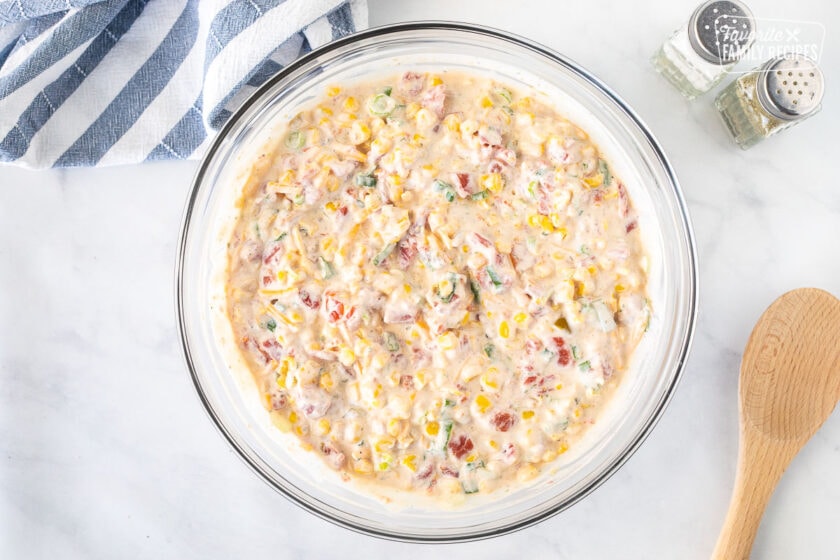 Bowl of mixed Creamy Corn Dip. Salt and Pepper on the side.