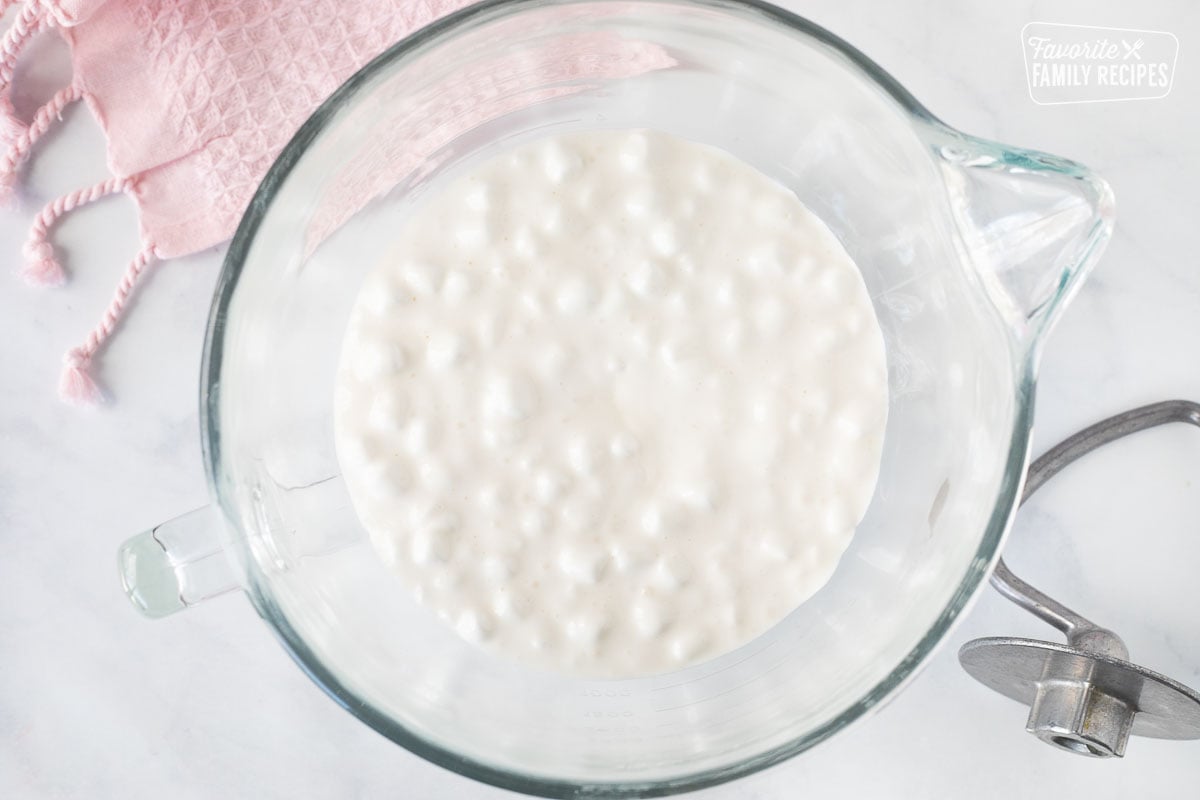 Mixing bowl with melted marshmallow mixture and dough hook to show How to Make Fondant.