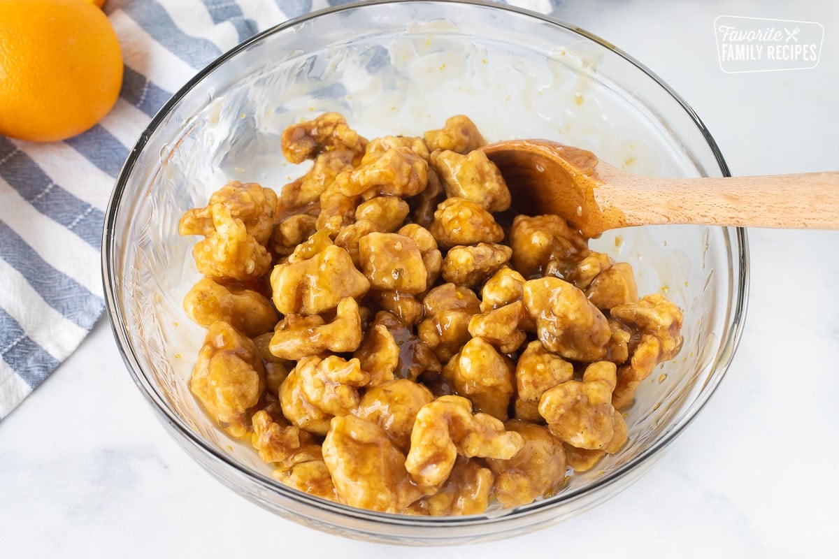 Stirring a bowl of saucy Orange Chicken.