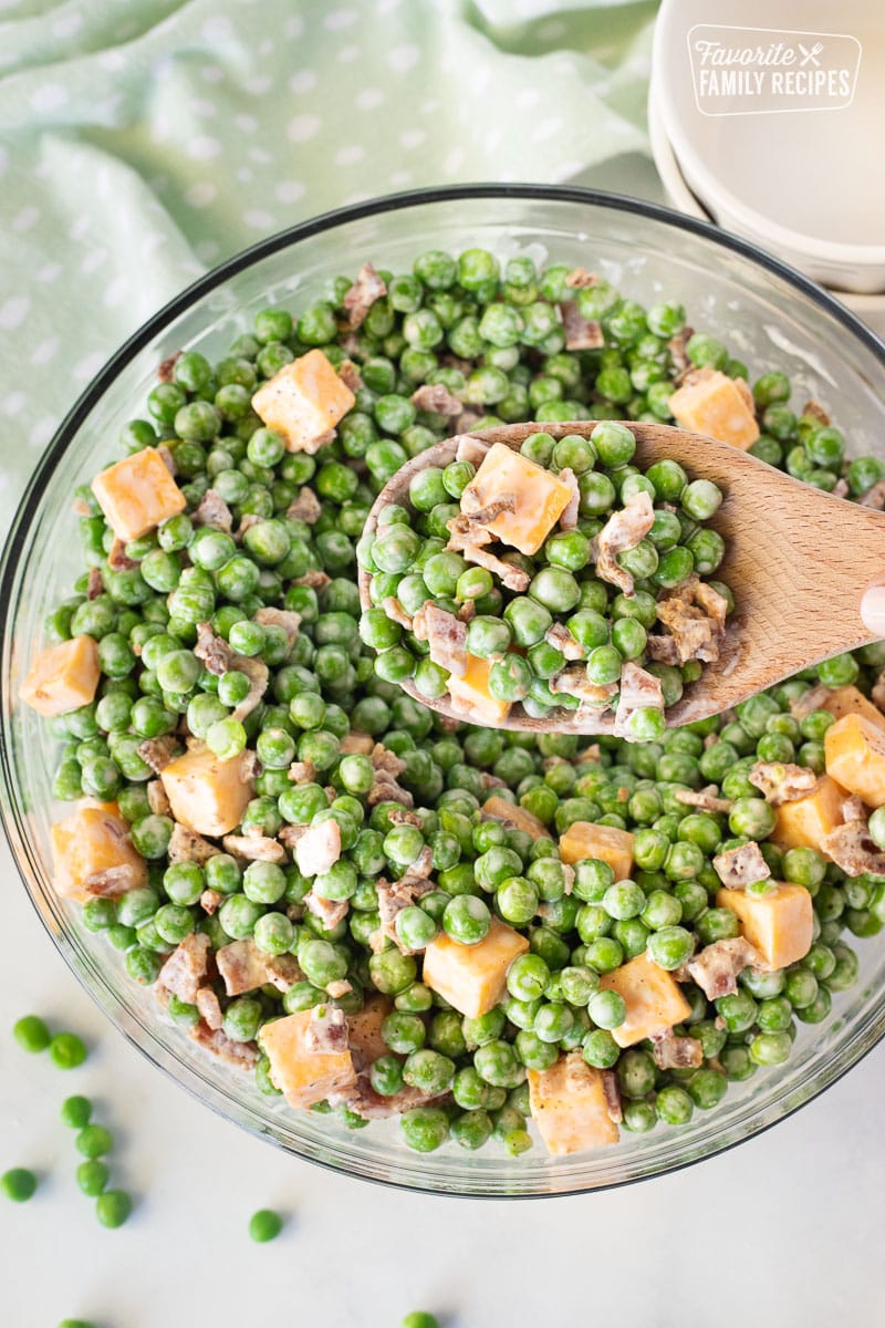 Spoon full of Green Pea Salad over the bowl of Green Pea Salad.
