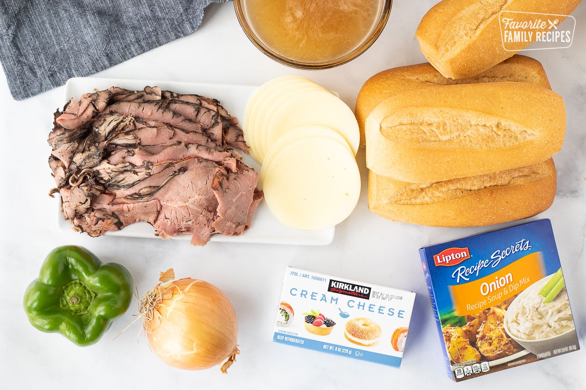 Philly Cheesesteak ingredients including rolls, beef broth, roast beef, provolone cheese, cream cheese, onion soup mix, green bell pepper and onion.