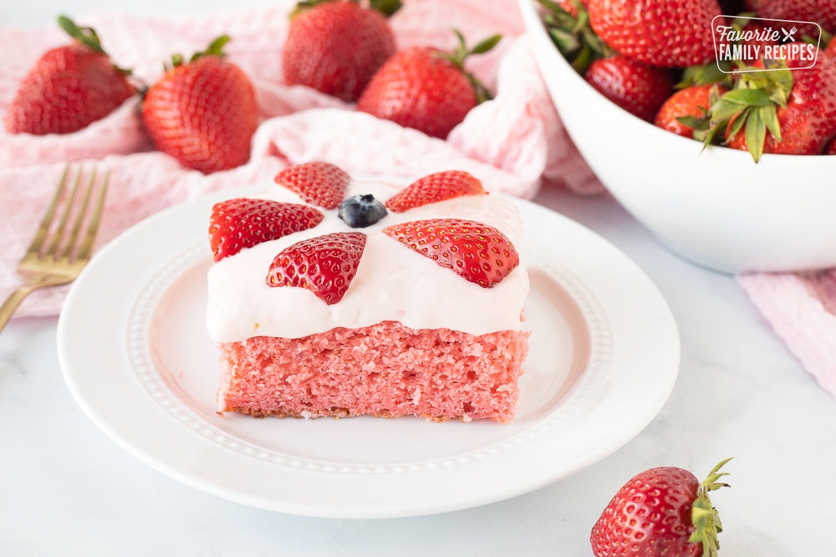 Pink Fresh Strawberry Cake frosted and decorated with strawberries and blueberry.