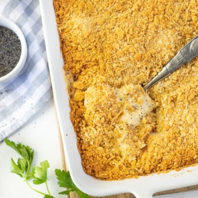 Spoon scooping in a baking dish of Poppy Seed Chicken.