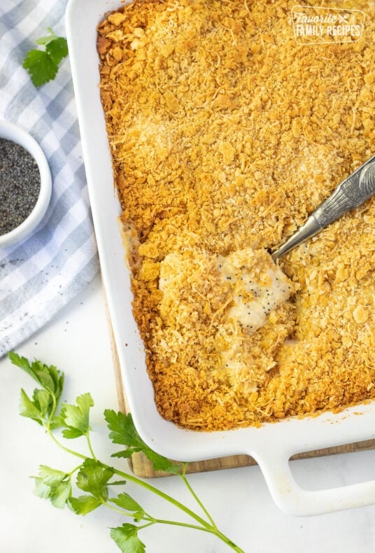 Spoon scooping in a baking dish of Poppy Seed Chicken.