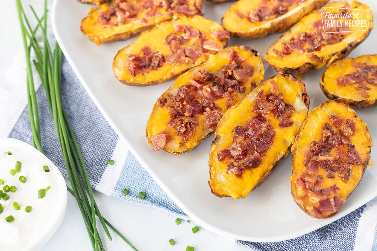Platter of Baked Potato Skins loaded with cheddar cheese and bacon.