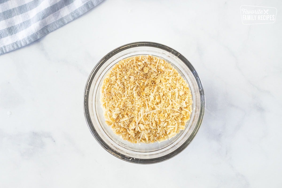 Glass bowl of Ritz crackers mixed with parmesan cheese for Poppy Seed Chicken.