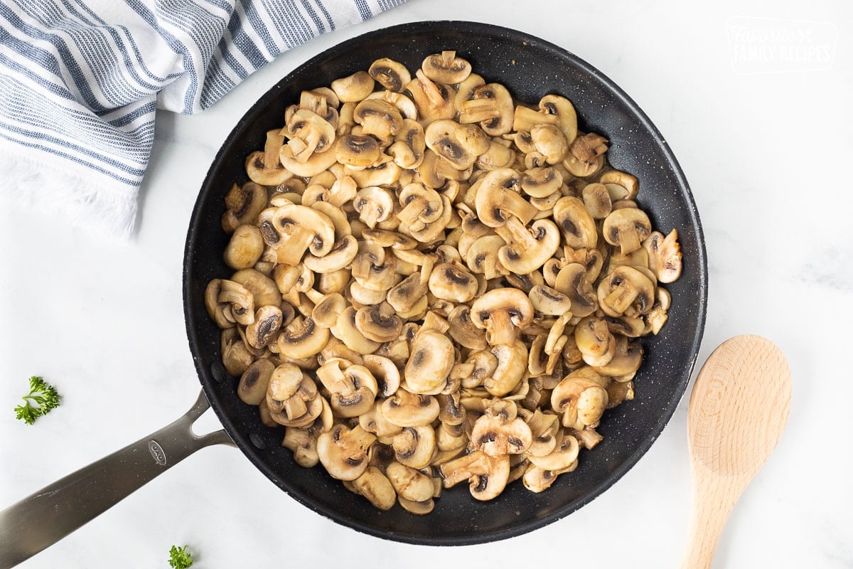 Sautéed mushrooms in a skillet for Chicken Marsala.