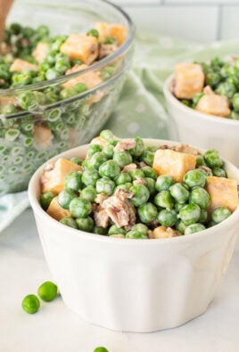 Serving bowls full of Green Pea Salad with forks.