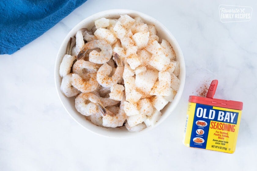 Bowl of raw shrimp and cod seasoned with Old Bay for Seafood Chowder.