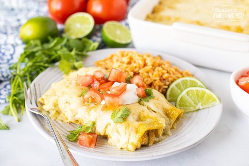 Honey Lime Chicken Enchiladas garnished with sour cream, tomatoes and cilantro.