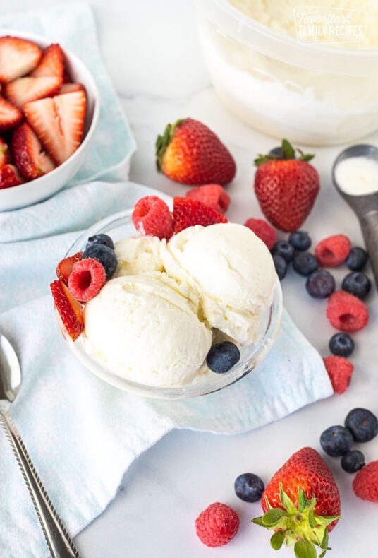 Scooped Homemade Vanilla Ice Cream with fresh berries in a bowl.